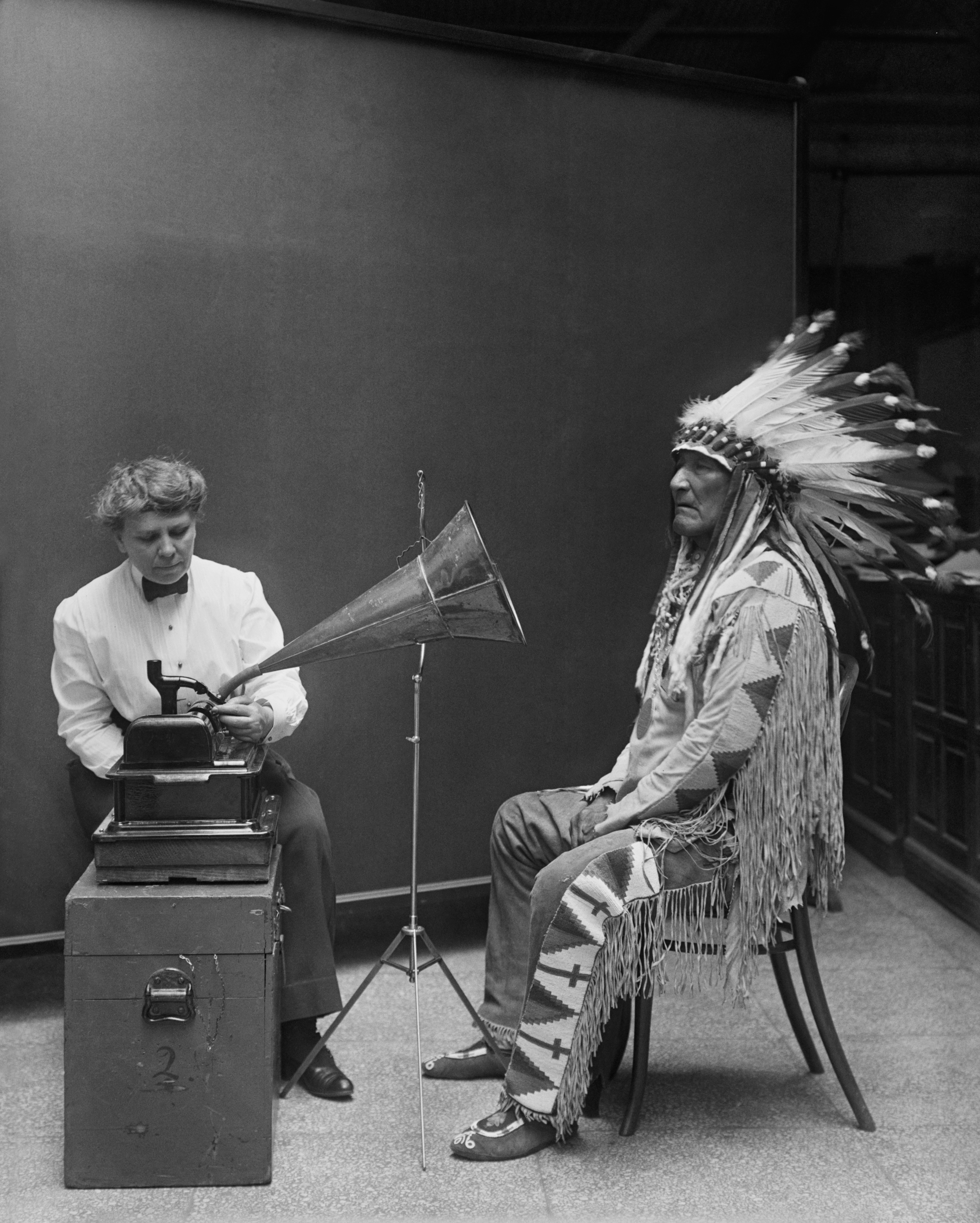 Black and white image of Frances Densmore recording the Blackfoot chief with a gramaphone