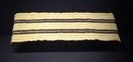 Photograph of beaded belt with two dark parallel lines on a lighter background
