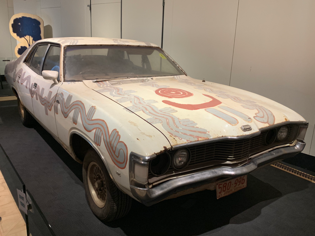 Colour photograph of a car painted with an Aboriginal design
