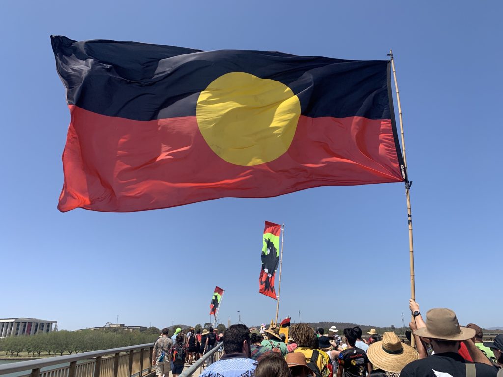 Aboriginal flag flying over a protest march